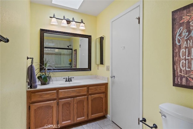 9 Benton Ave, Chico, CA 95973 - bathroom featuring a skylight, toilet, vanity, and tile patterned flooring