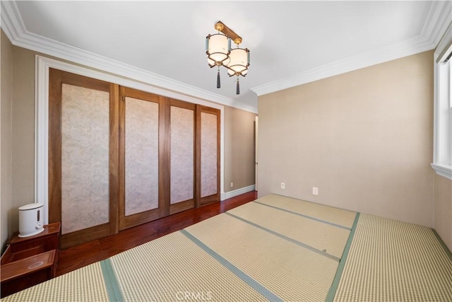 6829 Birmingham Dr, Chino, CA 91710 - empty room featuring wood finished floors, crown molding, and a chandelier