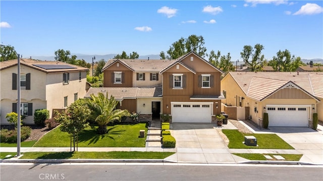 6829 Birmingham Dr, Chino, CA 91710 - traditional home with driveway, a mountain view, a front yard, and stone siding