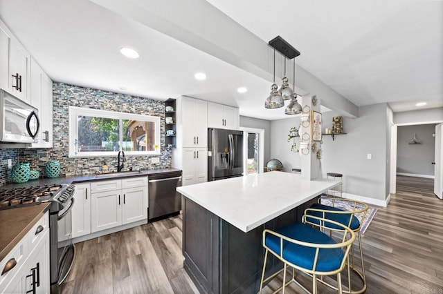 3221 Camarillo Ave, Oceanside, CA 92056 - kitchen with appliances with stainless steel finishes, a sink, wood finished floors, decorative backsplash, and recessed lighting