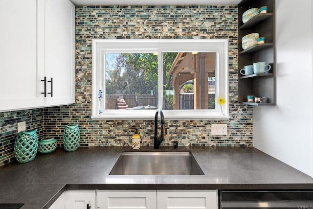 3221 Camarillo Ave, Oceanside, CA 92056 - kitchen with dark countertops, a sink, tasteful backsplash, white cabinets, and dishwasher