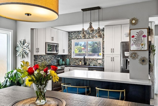3221 Camarillo Ave, Oceanside, CA 92056 - kitchen with appliances with stainless steel finishes, decorative backsplash, a sink, a peninsula, and white cabinetry
