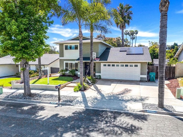 3221 Camarillo Ave, Oceanside, CA 92056 - traditional-style house featuring stucco siding, an attached garage, solar panels, concrete driveway, and roof with shingles