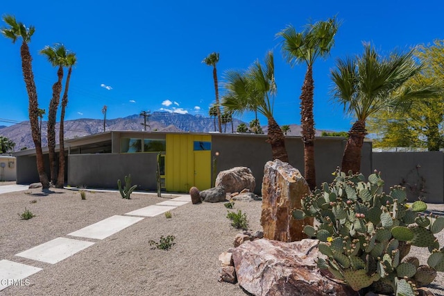 mid-century inspired home featuring a mountain view and fence