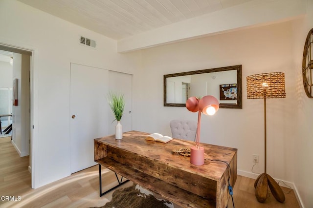 office featuring light wood-style flooring, baseboards, and beam ceiling
