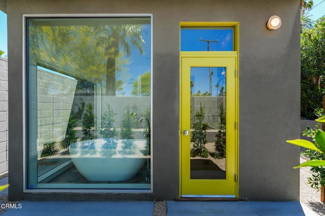 property entrance with stucco siding