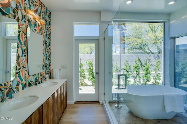 2839 N Davis Way, Palm Springs, CA 92262 - bathroom featuring a soaking tub, double vanity, healthy amount of natural light, wood finished floors, and recessed lighting