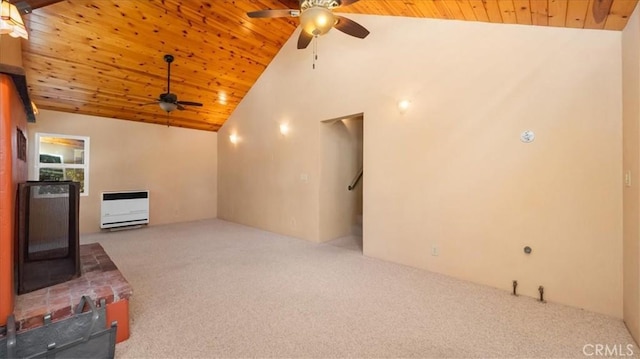 unfurnished living room with a ceiling fan, wood ceiling, carpet floors, a wood stove, and heating unit