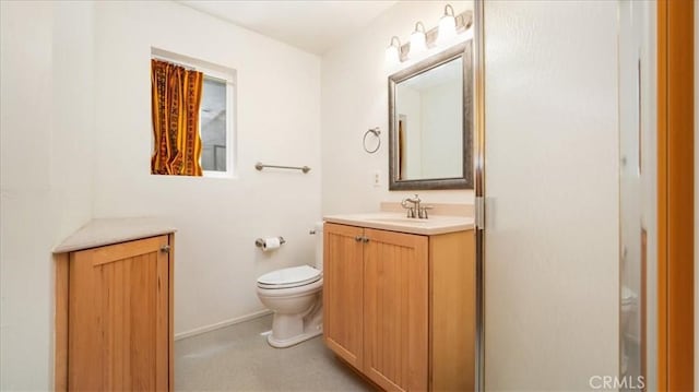 bathroom featuring vanity, toilet, and baseboards