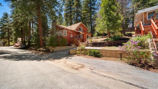 view of home's exterior featuring stairs, a chimney, and fence
