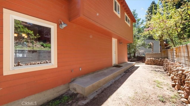 view of side of home featuring fence