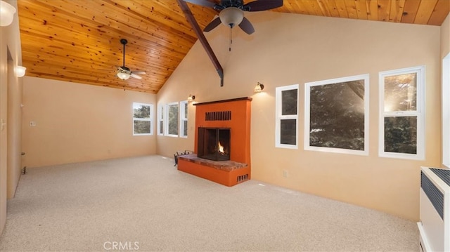 unfurnished living room with a ceiling fan, carpet flooring, a warm lit fireplace, wooden ceiling, and high vaulted ceiling