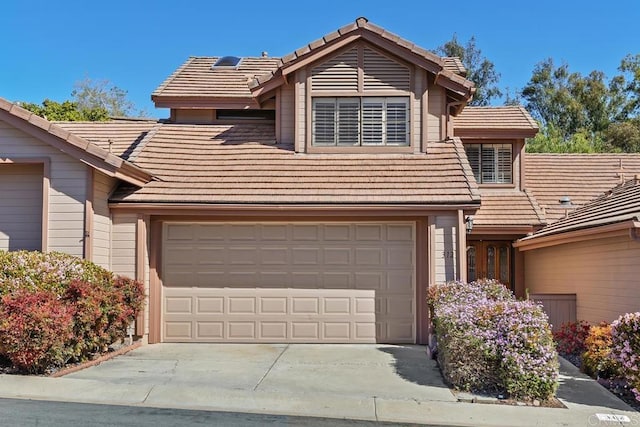 view of front facade with a tile roof and concrete driveway