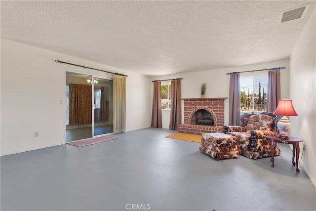 living room featuring a textured ceiling, healthy amount of natural light, finished concrete flooring, and a fireplace