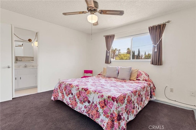 carpeted bedroom featuring a textured ceiling, a ceiling fan, ensuite bath, and a sink