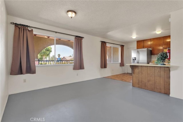 unfurnished living room with concrete flooring and a textured ceiling
