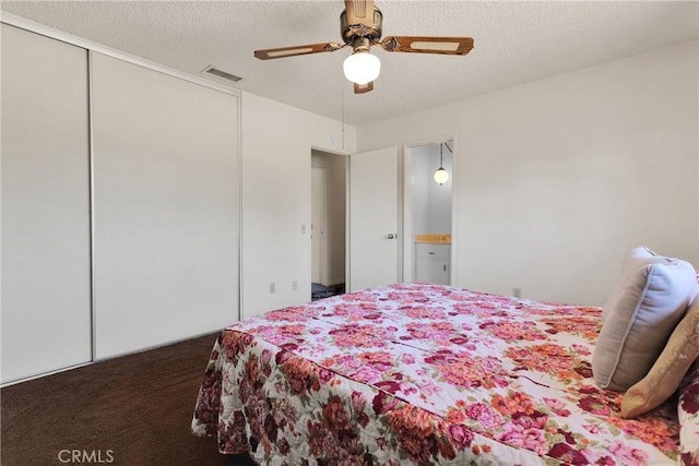 carpeted bedroom with a textured ceiling, a closet, and ceiling fan