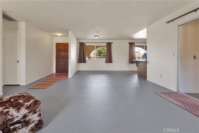 living area featuring concrete flooring and a textured ceiling