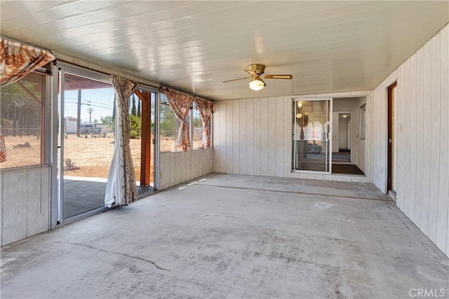 unfurnished sunroom featuring a ceiling fan
