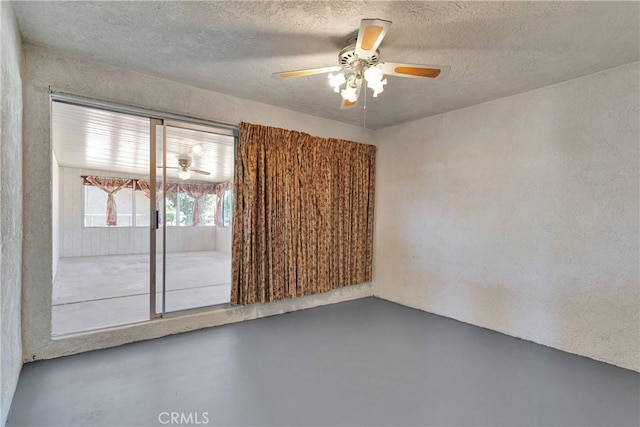 unfurnished room with ceiling fan, concrete flooring, and a textured ceiling