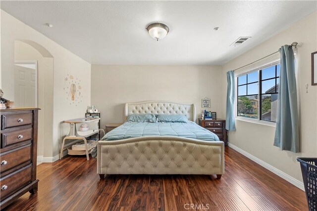3818 Coastal St, Riverside, CA 92501 - bedroom with dark wood-type flooring, arched walkways, and baseboards