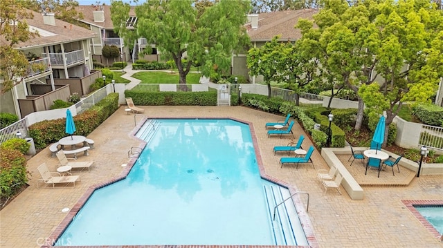 community pool with fence and a patio