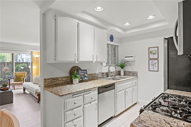 kitchen featuring dishwasher, a sink, gas range oven, recessed lighting, and white cabinets