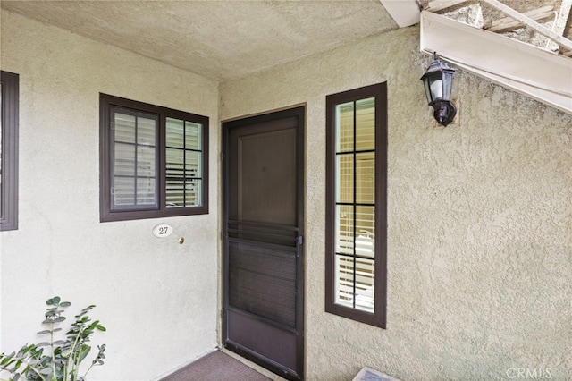 property entrance with stucco siding