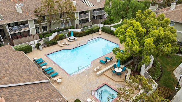 community pool featuring fence and a patio