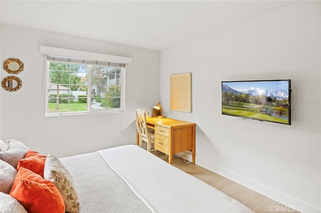 bedroom with wood finished floors and baseboards