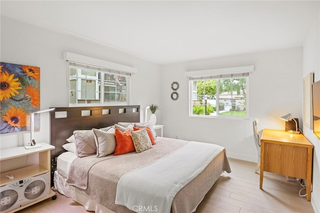 bedroom with light wood-type flooring and baseboards