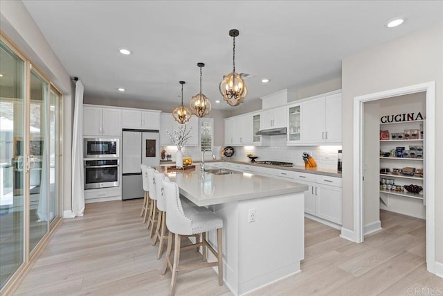 940 Lindbergh Dr, San Marcos, CA 92069 - kitchen featuring stainless steel appliances, a chandelier, light wood-style floors, tasteful backsplash, and white cabinets