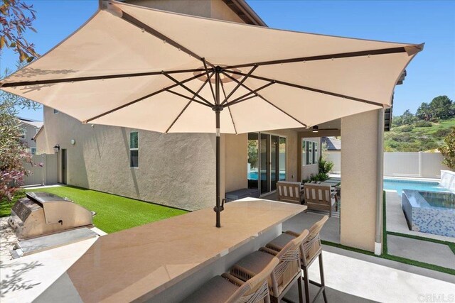 940 Lindbergh Dr, San Marcos, CA 92069 - fenced backyard featuring exterior kitchen, a patio, and a ceiling fan