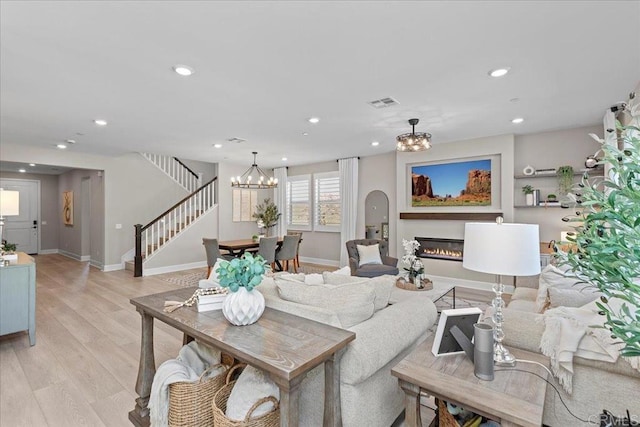 940 Lindbergh Dr, San Marcos, CA 92069 - living area featuring a chandelier, recessed lighting, stairs, a glass covered fireplace, and light wood-style floors