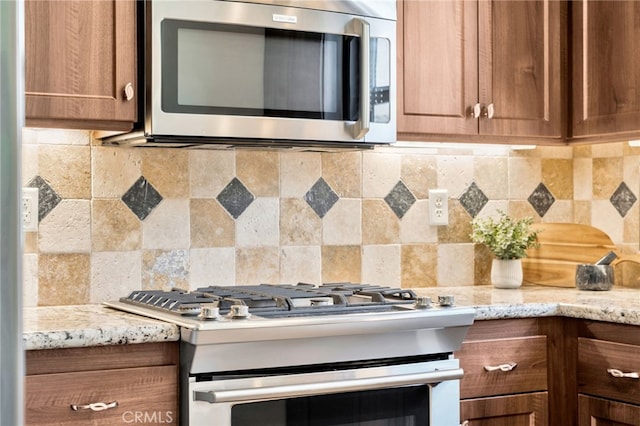 kitchen with appliances with stainless steel finishes, decorative backsplash, and brown cabinets