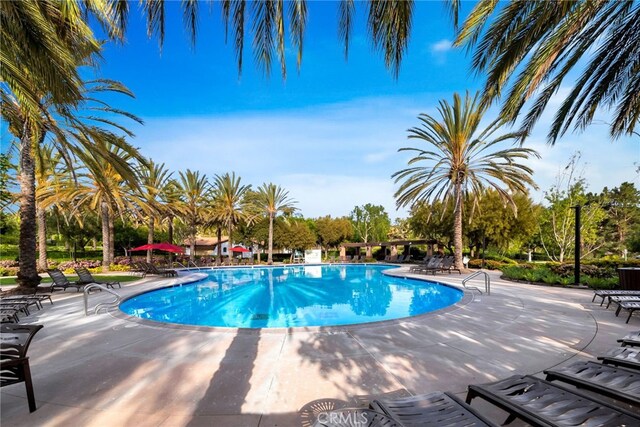 community pool featuring a patio and cooling unit
