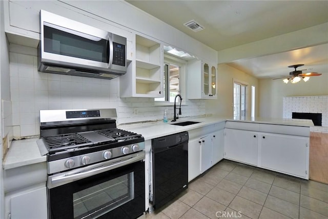 kitchen with appliances with stainless steel finishes, a sink, tasteful backsplash, and light countertops
