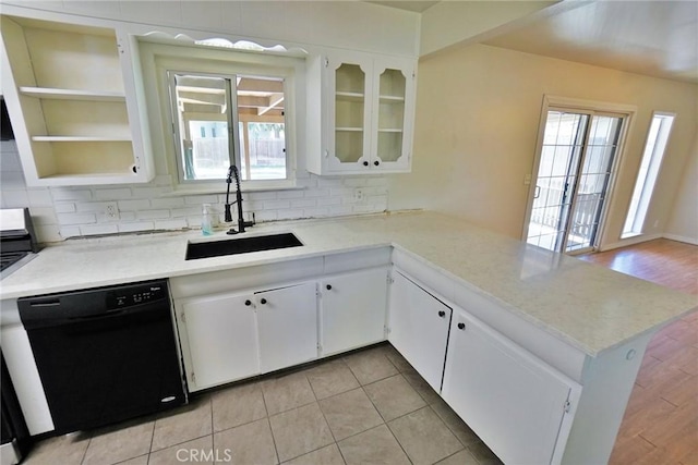 kitchen featuring black dishwasher, a sink, and light countertops