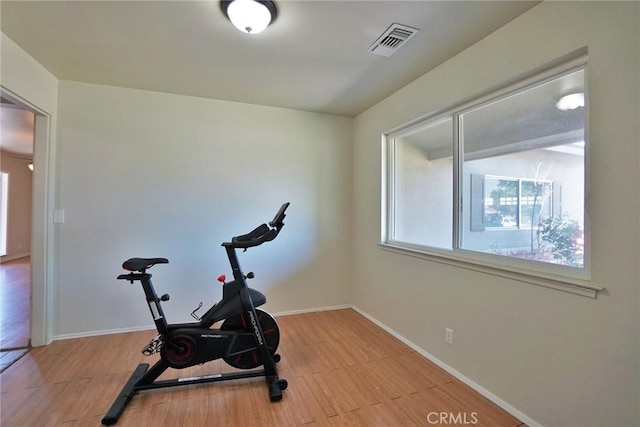 exercise room with wood finished floors and baseboards