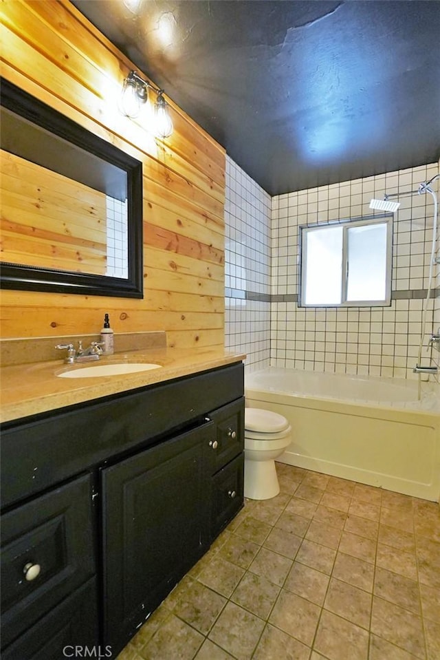 full bathroom featuring tile patterned floors, toilet, vanity, shower / washtub combination, and wooden walls