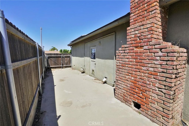 view of side of home with fence and a patio