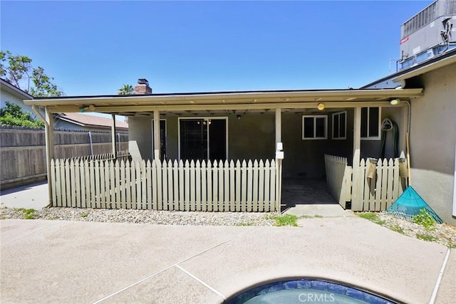 back of property featuring stucco siding and a chimney