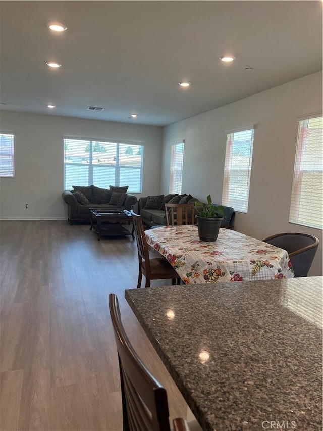 dining space featuring wood finished floors, recessed lighting, and baseboards