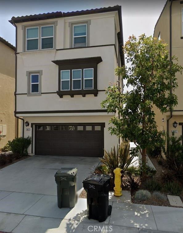view of front of house featuring concrete driveway, an attached garage, and stucco siding