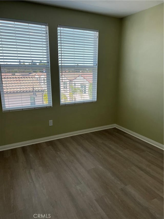 spare room featuring wood finished floors and baseboards
