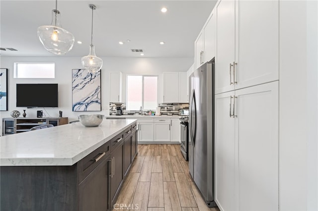54060 Avenida Madero Ln, Quinta, CA 92253 - kitchen featuring freestanding refrigerator, plenty of natural light, white cabinets, light stone countertops, and recessed lighting