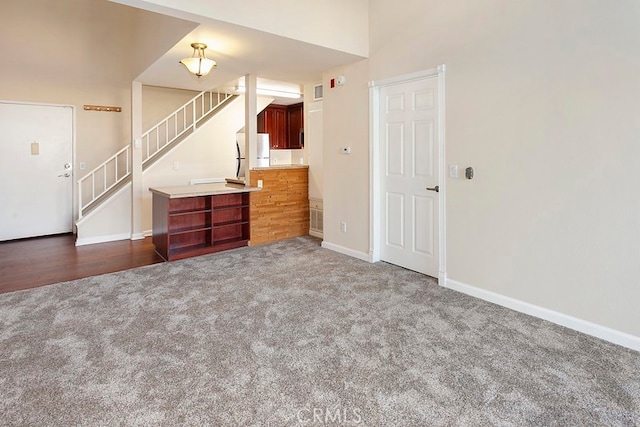 5530 Owensmoutth Ave Unit 306, Woodland Hills, CA 91367 - unfurnished living room featuring carpet flooring, stairway, and baseboards