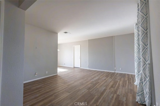 unfurnished room featuring wood finished floors and baseboards