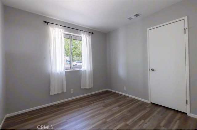 unfurnished room with wood finished floors and baseboards