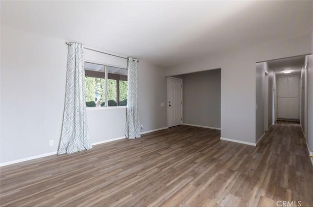 unfurnished room with wood finished floors and baseboards